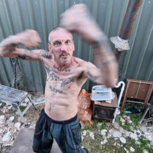 David Hesketh, shirtless and with fists raised like he's in a fight