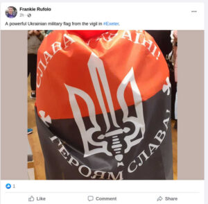 Facebook post by Frankie Rufolo: "A powerful Ukrainian military flag from the vigil in #Exeter". Followed by a picture of the UPA flag, with "glory to ukraine! Glory to heroes!" written on it in Ukrainian