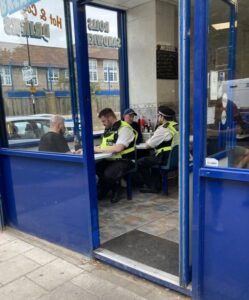 Nick Tenconi sat in a cafe with a police officer